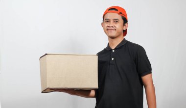 Kutu taşıyan arkadaş canlısı teslimatçı kapına gülümseyerek hızlı bir nakliyat ve kusursuz bir servis sunuyor.