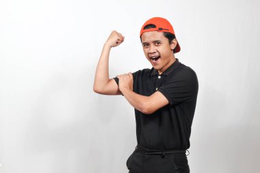 Heyecanlı genç adam turuncu başlıklı kaslarını güç, zindelik ve sağIık için beyaz zemine yaslıyor.