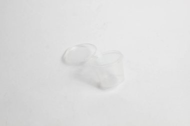 Beyaz arkaplanda izole edilmiş küçük şeffaf biber sosu kavanozu.