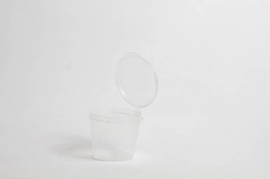 Beyaz arkaplanda izole edilmiş küçük şeffaf biber sosu kavanozu.