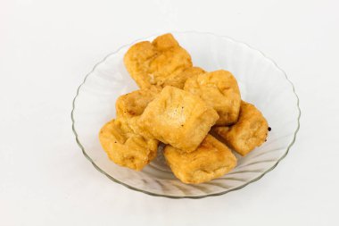 Zarif cam tabakta servis edilen kızarmış tofu küpleri lezzetli vejetaryen yemekleri ve sağlıklı yemekler için hazır.