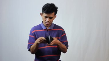 Zavallı Asyalı adam beyaz arka planda izole bir cüzdan gösteriyor. Finansal konsept, iflas.