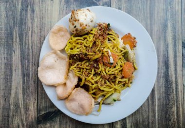 Ahşap bir masada tabakta geleneksel Gado Gado yemeklerinin en alttaki görüntüsü. Tofu, tempeh, uzun fasulye, havuç, fıstık sosu, kraker ve haşlanmış yumurtadan yapılır..