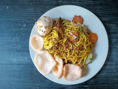 Ahşap bir masada tabakta geleneksel Gado Gado yemeklerinin en alttaki görüntüsü. Tofu, tempeh, uzun fasulye, havuç, fıstık sosu, kraker ve haşlanmış yumurtadan yapılır..