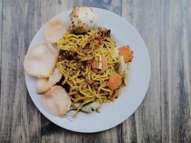 Ahşap bir masada tabakta geleneksel Gado Gado yemeklerinin en alttaki görüntüsü. Tofu, tempeh, uzun fasulye, havuç, fıstık sosu, kraker ve haşlanmış yumurtadan yapılır..