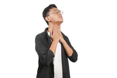 Gözlüklü ve siyah tişörtlü Asyalı bir adam beyaz arka planda boğaz ağrısı çekiyor.