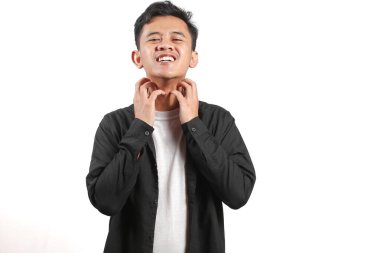 Tüm vücudu kaşınan siyah tişörtlü Asyalı bir adam.