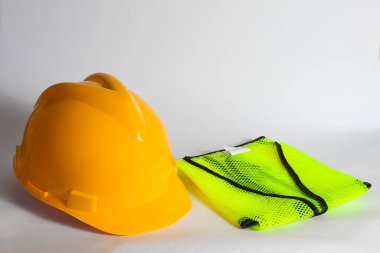 Güvenlik ve inşaat temaları vurgulanarak, beyaz arka planda sarı başlık ve katlanmış yansıtıcı güvenlik yeleği.