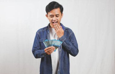 Sırt çantalı genç bir adam, Endonezya Rupiah 'ının elinde macerasına hazır olmasından heyecan duyuyor. Olasılıkları, seyahat ve finansal özgürlüğü hayal edin.!