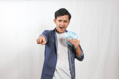 Sırt çantalı genç bir adam, Endonezya Rupiah 'ının elinde macerasına hazır olmasından heyecan duyuyor. Olasılıkları, seyahat ve finansal özgürlüğü hayal edin.!