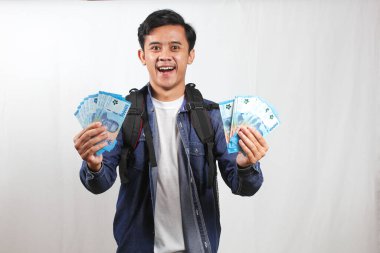 Kot gömlek ve çanta giyen Asyalı öğrenciler 50 bin rupia 'lık banknotlar bulundurmaktan çok mutlular. Okul sübvansiyon yardımı alanlar konsepti