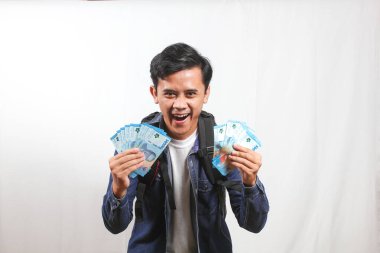 Kot gömlek ve çanta giyen Asyalı öğrenciler 50 bin rupia 'lık banknotlar bulundurmaktan çok mutlular. Okul sübvansiyon yardımı alanlar konsepti