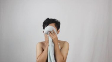 Duştan sonra yüzü yumuşak havluyla kurulanan bir adam taze, temiz bir his, kişisel bakım ve hijyeni teşvik etmek, hayat tarzı reklamı için mükemmel.