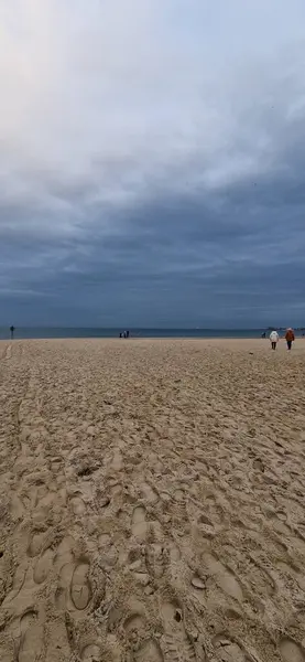 Portekiz 'deki bulutlu gökyüzünün altında kumlu bir plajın güzel bir görüntüsü.
