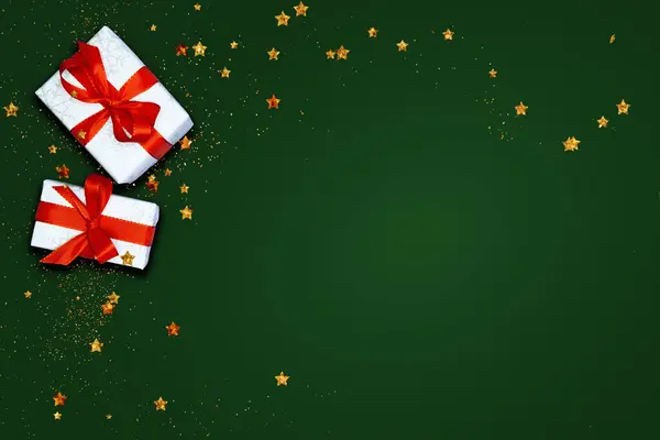 Yeşil arka planda Noel süsleri ve hediye, üst manzara.