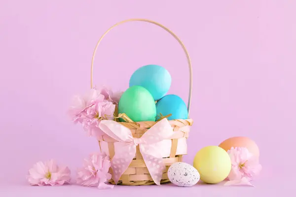 Beyaz arka planda renkli Paskalya yumurtalarıyla dolu Paskalya sepeti.