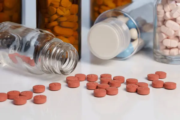 Sarı ve beyaz ilaç şişeleri ve haplar..