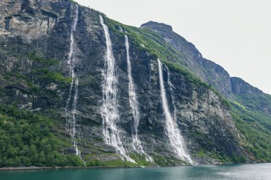 Norveç 'teki Geirangerfjord Fjord Kuzey Kutup Dairesi dağlarının güzel manzarası. Geiranger Fjord Norveç 'in Mre og Romsdal bölgesinin Sunnmre bölgesinde bulunan bir fiyorttur. Tamamıyla Stranda Belediyesinde yer almaktadır.