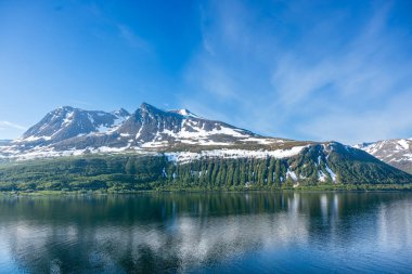 Norveç 'teki Hjrundfjorden Fjord, Kuzey Kutup Dairesi dağlarının güzel manzarası. Hjrundfjorden Norveç 'in Mre og Romsdal ilçesinin geleneksel Sunnmre ilçesine bağlı bir fiyorttur..