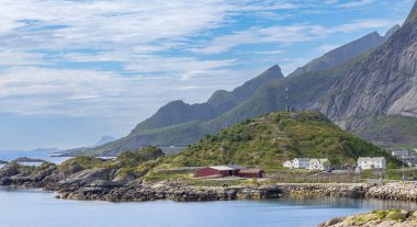 Hamny Village, Lofoten Adaları, Hamnya, Moskenesya, Norveç. Renkli evleri olan dağların güzel manzarası İskandinavya 'ya özgü ve Kuzey Kutup Dairesi' ndeki botlar.