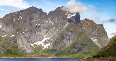Hamny Village, Lofoten Adaları, Hamnya, Moskenesya, Norveç. Renkli evleri olan dağların güzel manzarası İskandinavya 'ya özgü ve Kuzey Kutup Dairesi' ndeki botlar.