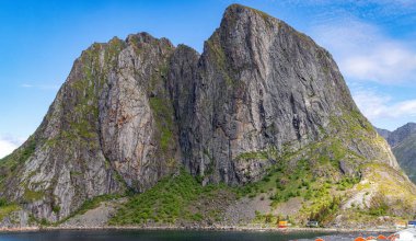 Hamny Village, Lofoten Adaları, Hamnya, Moskenesya, Norveç. Renkli evleri olan dağların güzel manzarası İskandinavya 'ya özgü ve Kuzey Kutup Dairesi' ndeki botlar.