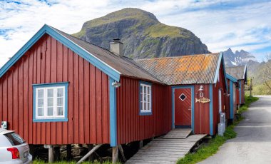 Srvgen Köyü, Lofoten Adaları, Moskenesya, Norveç. İskandinavya 'nın tipik kırmızı evleri olan dağların güzel manzarası