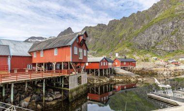Srvgen Köyü, Lofoten Adaları, Moskenesya, Norveç. İskandinavya 'nın tipik kırmızı evleri olan dağların güzel manzarası