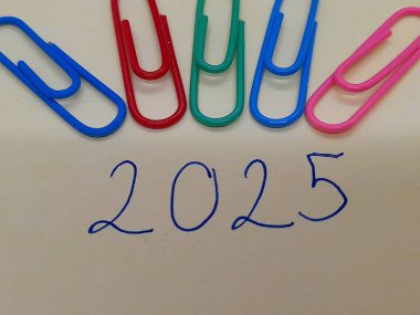 Renkli ataçlı 2025 altyazı veya metin.