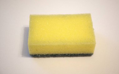 Metin için kopyalama alanı olan beyaz arkaplandaki tek bir bulaşık süngerinin yakın çekimi.