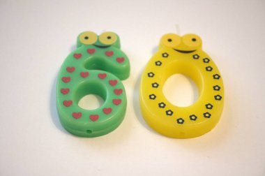 60 numaralı renkli bir doğum günü mumu temiz beyaz bir zeminde dikiliyor. Kutlama temaları için kopyalama alanı olan resmi kapat.