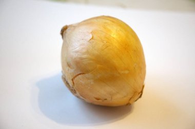 Kahverengi soğanın fotokopi alanı olan düz beyaz bir arkaplana yerleştirilmiş hali. Yemek pişirmek ya da mutfak malzemesi temaları için mükemmel..