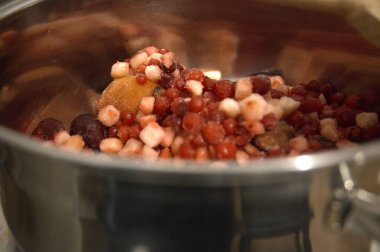 Geleneksel meyve çorbası yapmak için hazırlanmış donmuş meyvelerle dolu bir tencere. Yemek pişirmeden önce malzemelerin yakınlaştırılması.