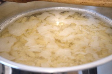 Fırının içinde sıcak suda pişen çiğ makarna, ev yapımı pişirme konsepti..