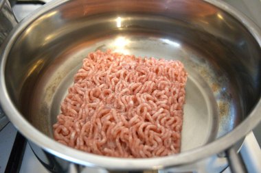 Bir tencerede yağda pişen çiğ et, yemek hazırlığının başlangıcı..