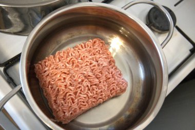 Bir tencerede yağda pişen çiğ et, yemek hazırlığının başlangıcı..