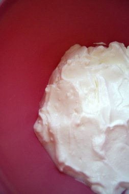 Fotokopi alanı olan pembe bir kasede servis edilen ekşi krema yakın plan, aşçılık ve yemek tarifi kullanımı için ideal..