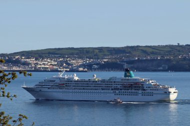 Römorkörü olan büyük bir yolcu gemisi.