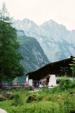 Almanya 'da Bavyera' da Konigssee Gölü kıyısındaki ahşap ev, Berchtesgaden Alman Alpleri 'nde Beyaz Tekne Ormanı Dağları' ndaki Kilise ve Güzel Güneşli Yolculuk. Yüksek kalite fotoğraf