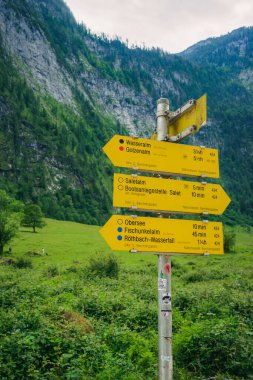 Bavyera 'da Konigssee Gölü' ne doğru sarı dağ levhası istikameti, Berchtesgaden Alman Alpleri 'nde Beyaz Bot Ormanı Dağları' ndaki Kilise ve Güzel Güneşli Yolculuk. Yüksek kalite fotoğraf