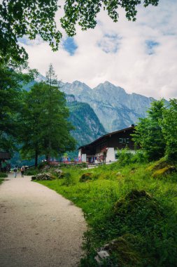 Almanya 'da Bavyera' da Konigssee Gölü kıyısındaki ahşap ev, Berchtesgaden Alman Alpleri 'nde Beyaz Tekne Ormanı Dağları' ndaki Kilise ve Güzel Güneşli Yolculuk. Yüksek kalite fotoğraf