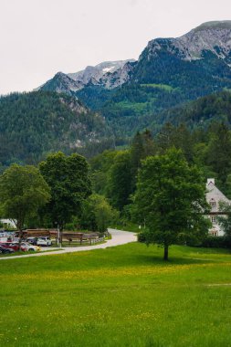 Scenic countryside view featuring traditional buildings surrounded by lush greenery in a tranquil rural setting Konigssee Bavaria German Apls. High quality photo clipart