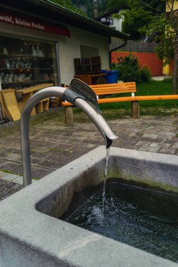 Tatlı su, yemyeşil yemyeşil ve basit ahşap banklarla çevrili metal bir oluktan yavaşça taştan bir oluğa akar ve barışçıl bir atmosfer yaratır. Konigssee Bavyera Alman Alpleri