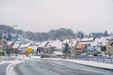 Büyülü kış mevsiminde büyüleyici küçük bir köyde zarif bir şekilde dönen karlı bir yol.