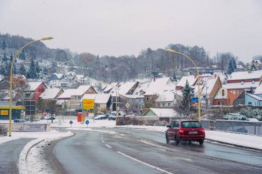 Büyülü kış mevsiminde büyüleyici küçük bir köyde zarif bir şekilde dönen karlı bir yol.