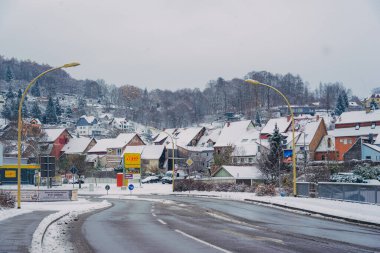 Büyülü kış mevsiminde büyüleyici küçük bir köyde zarif bir şekilde dönen karlı bir yol.