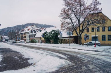 Büyülü kış mevsiminde büyüleyici küçük bir köyde zarif bir şekilde dönen karlı bir yol.