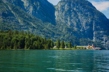 Konigssee Lake in Bavaria Germany with Church by the Lake White Boat Forested Mountain and Beautiful Sunny Trekking in Berchtesgaden German Alps. High quality photo clipart