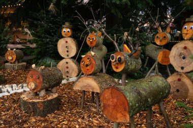 Renkli ahşap figürler rahat bir bahçede tuhaf bir tatil gösterisi yaratarak şenlikli ruhu canlandırıyor.