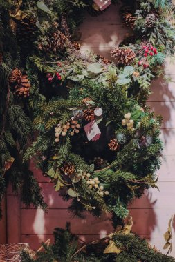 Close-up of a Christmas wreath with pinecones, red berries, and greenery. High quality photo clipart